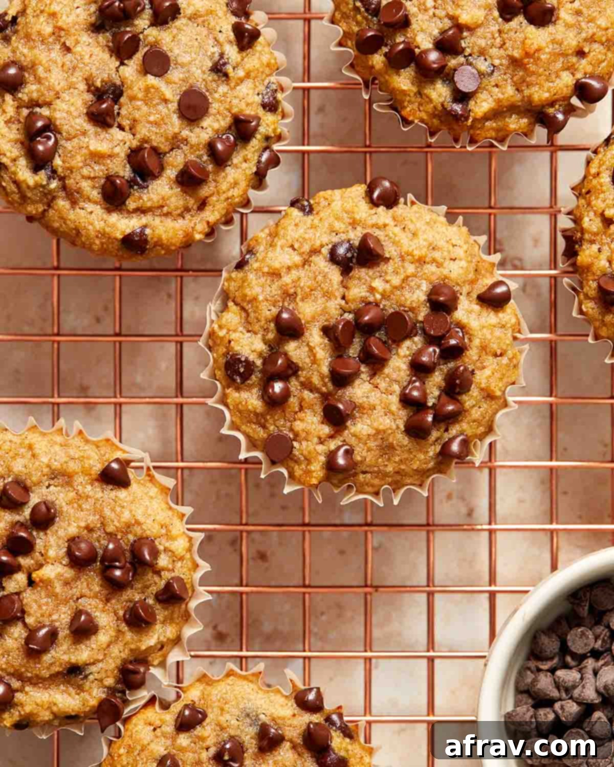 Irresistible Almond Flour Banana Muffins 7 Banana chocolate chip muffins arranged on a wire cooling rack.