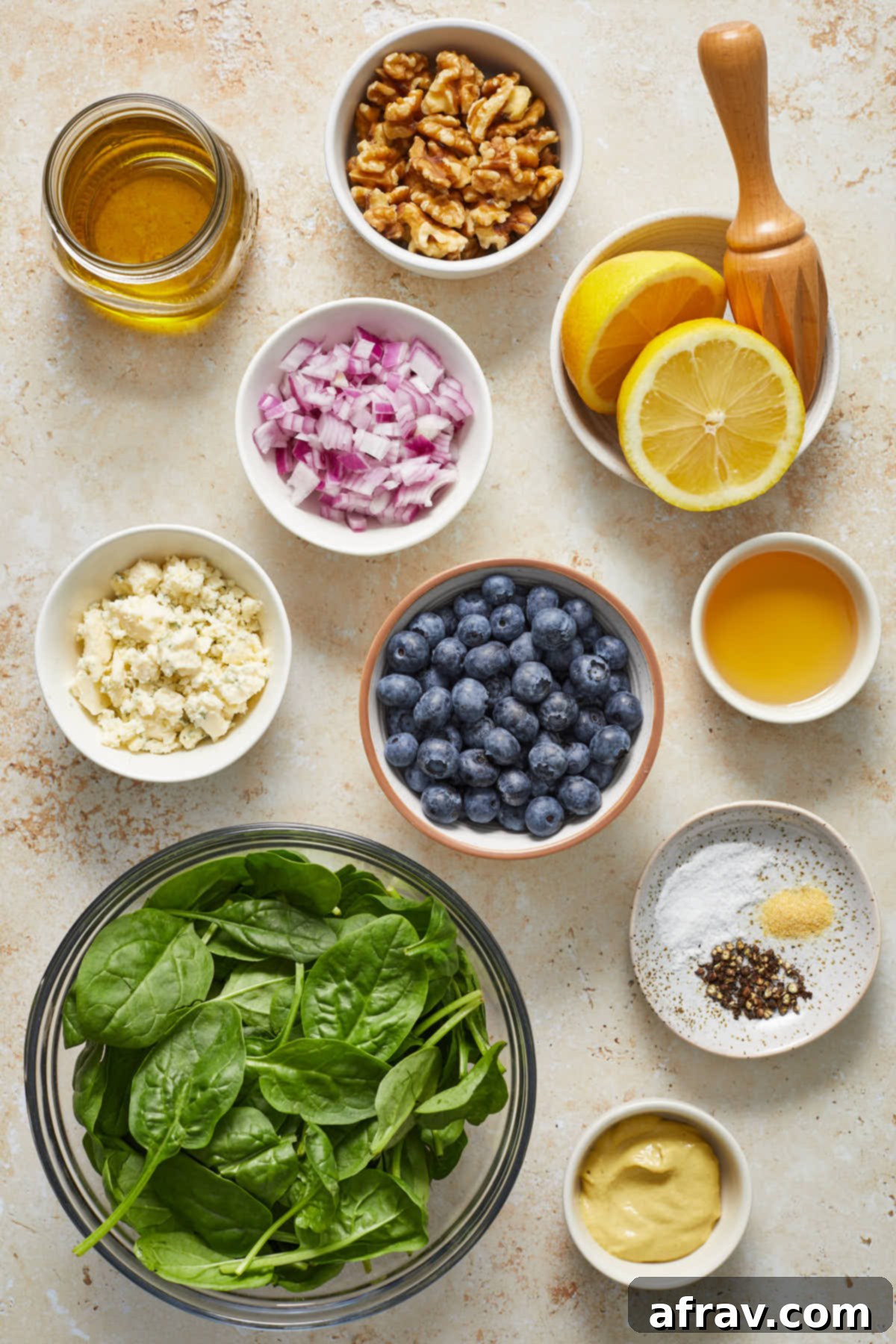 Ingredients to make blueberry spinach salad arranged in individual bowls.