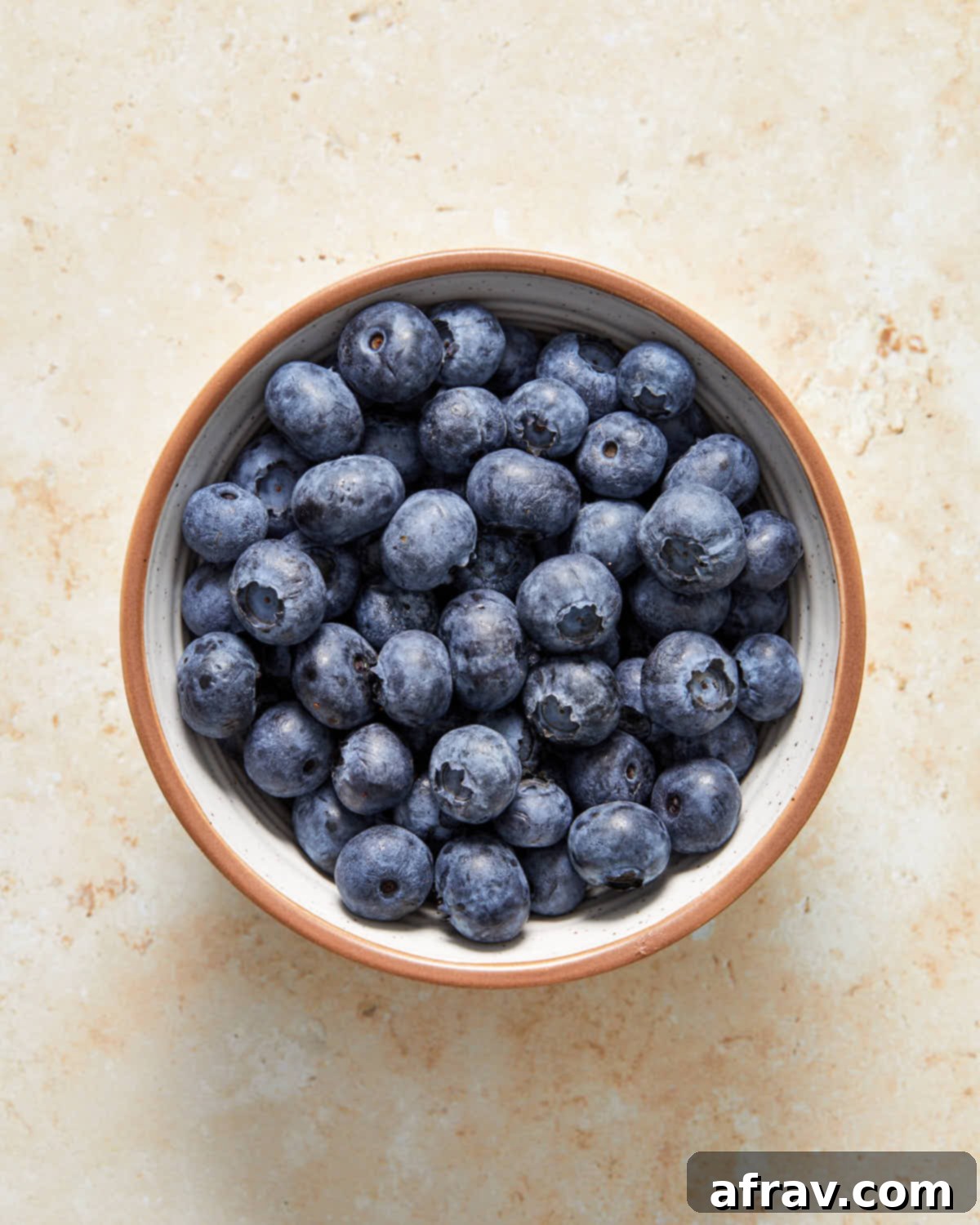 Overhead view of fresh blueberries in a white bowl.
