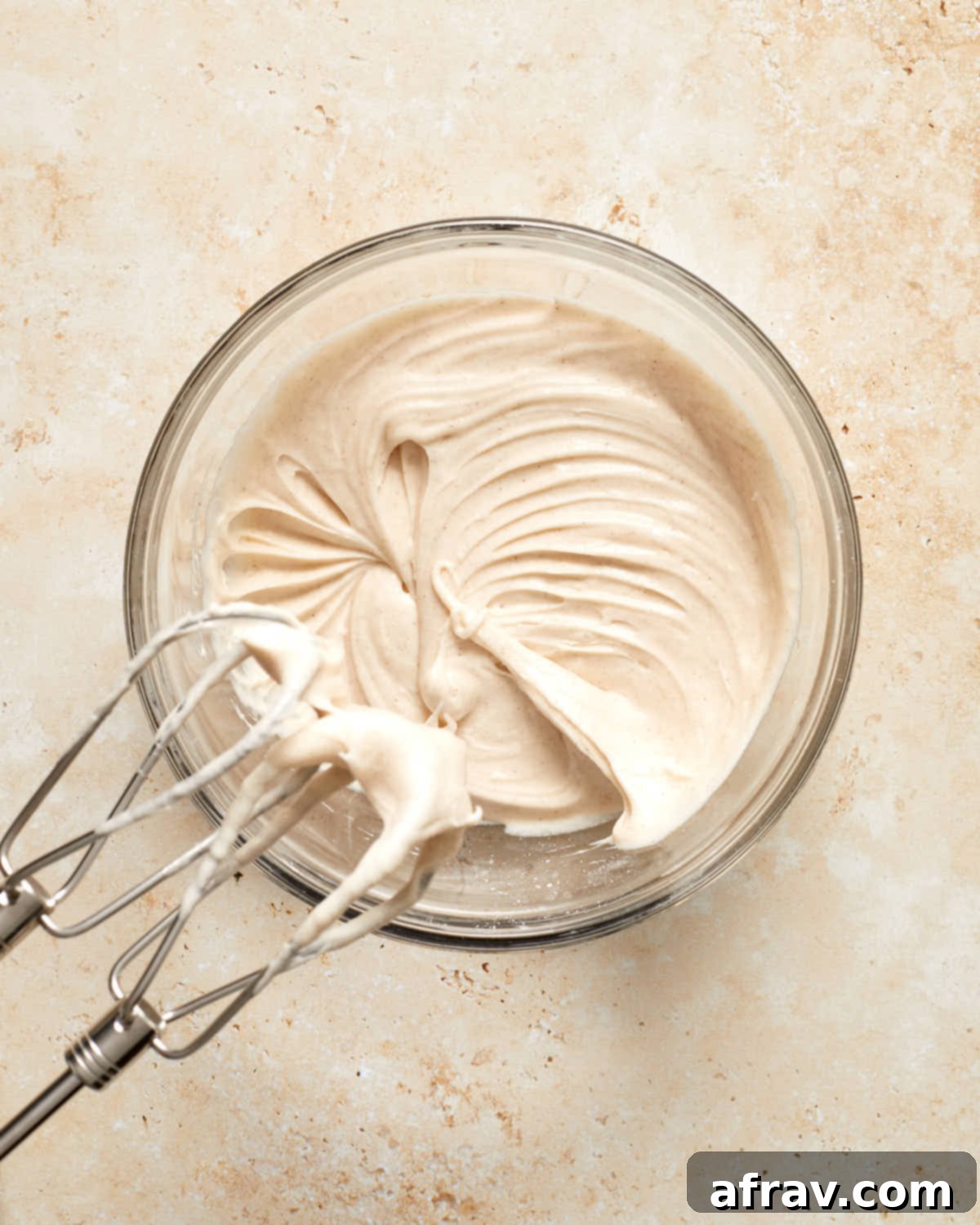 Cinnamon cream cheese frosting in a glass bowl.