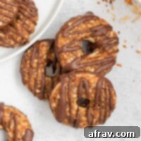 Three healthy Samoa cookies slightly stacked on a gray surface, featuring their rich caramel, coconut, and chocolate layers.