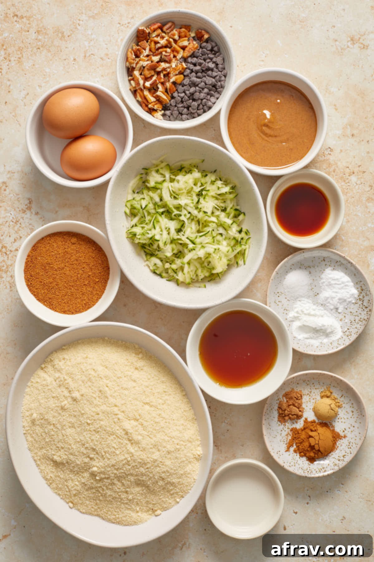 Ingredients to make almond flour zucchini muffins arranged in individual dishes.