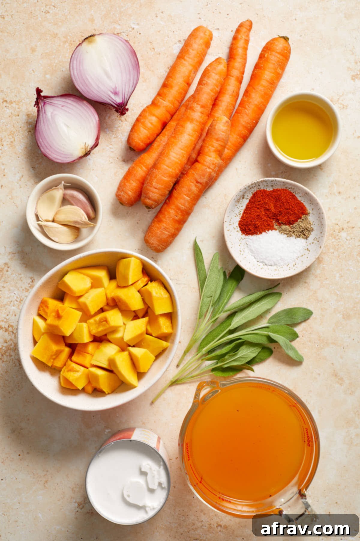 Ingredients to make carrot and butternut squash soup arranged individually.