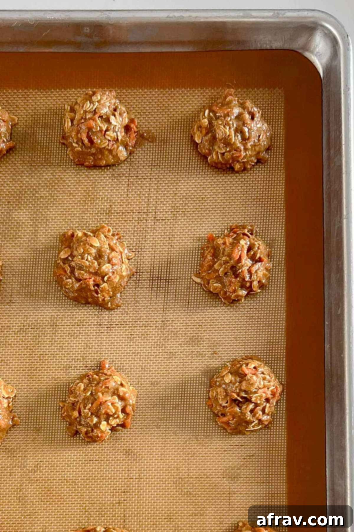 Spiced Carrot Oatmeal Delights 7 Carrot cake oatmeal cookie dough balls on a cookie sheet.