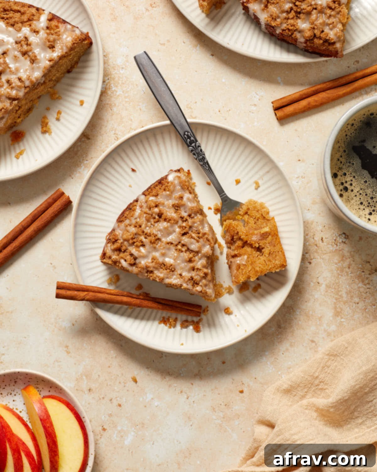 Delightful Almond Apple Cake 14 Slice of apple cake with fork removing piece and cup of coffee on the side.