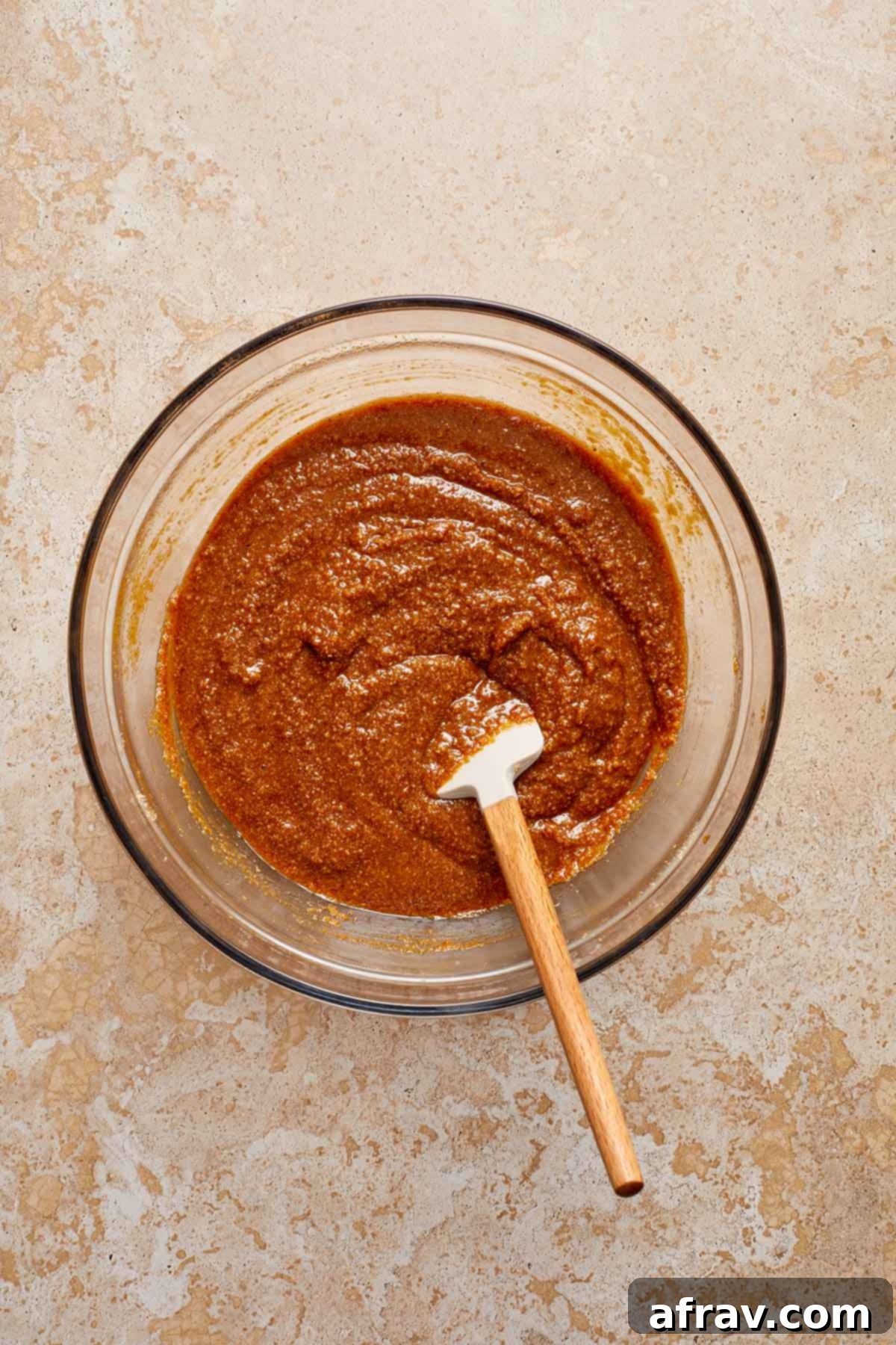 Moist Almond Flour Gingerbread Cake 6 Cake batter in a glass bowl with a spatula inserted into it.