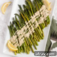 Easy Roasted Asparagus with Creamy Lemon Tahini Sauce 6 overhead view of roasted asparagus with tahini on white serving plate
