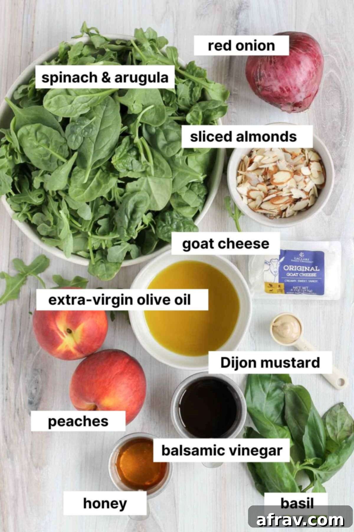 Labeled ingredients for peach and goat cheese salad, including spinach, arugula, peaches, goat cheese, red onion, basil, and dressing ingredients.