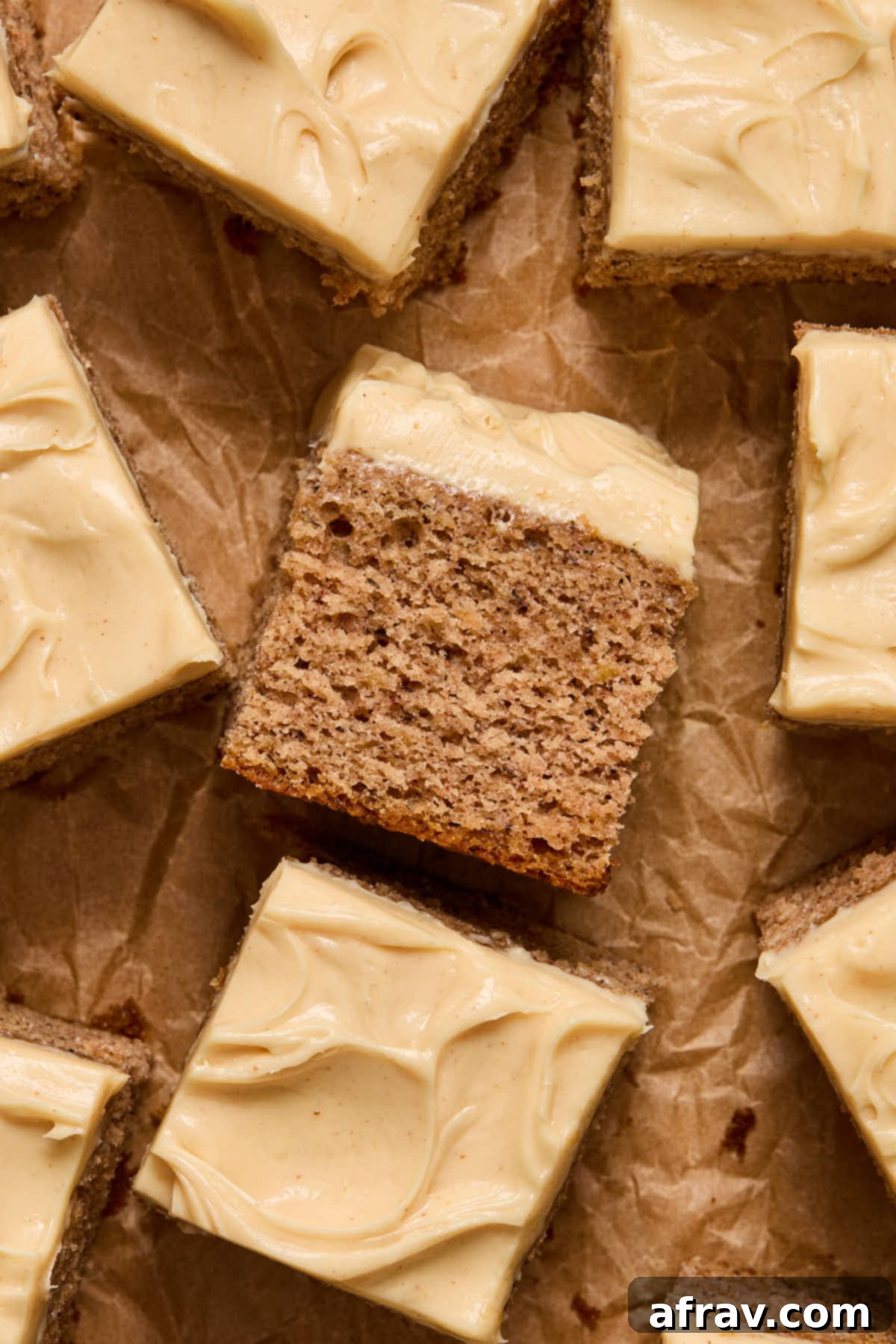 Close up of a piece of cake turned on its side, showcasing its moist texture and generous frosting.
