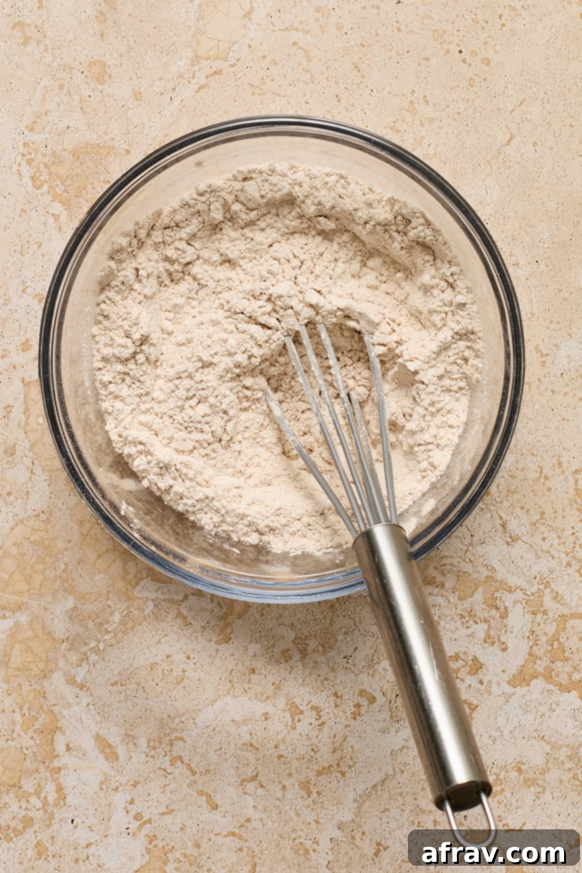Dry ingredients whisked together in a glass bowl.