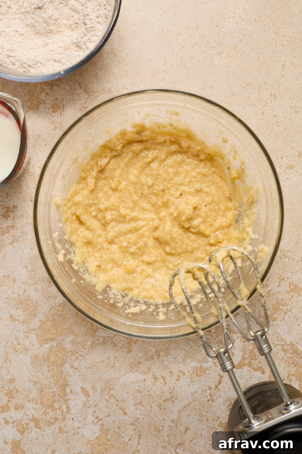Wet ingredients mixed together, showing egg, vanilla, and mashed banana incorporated.