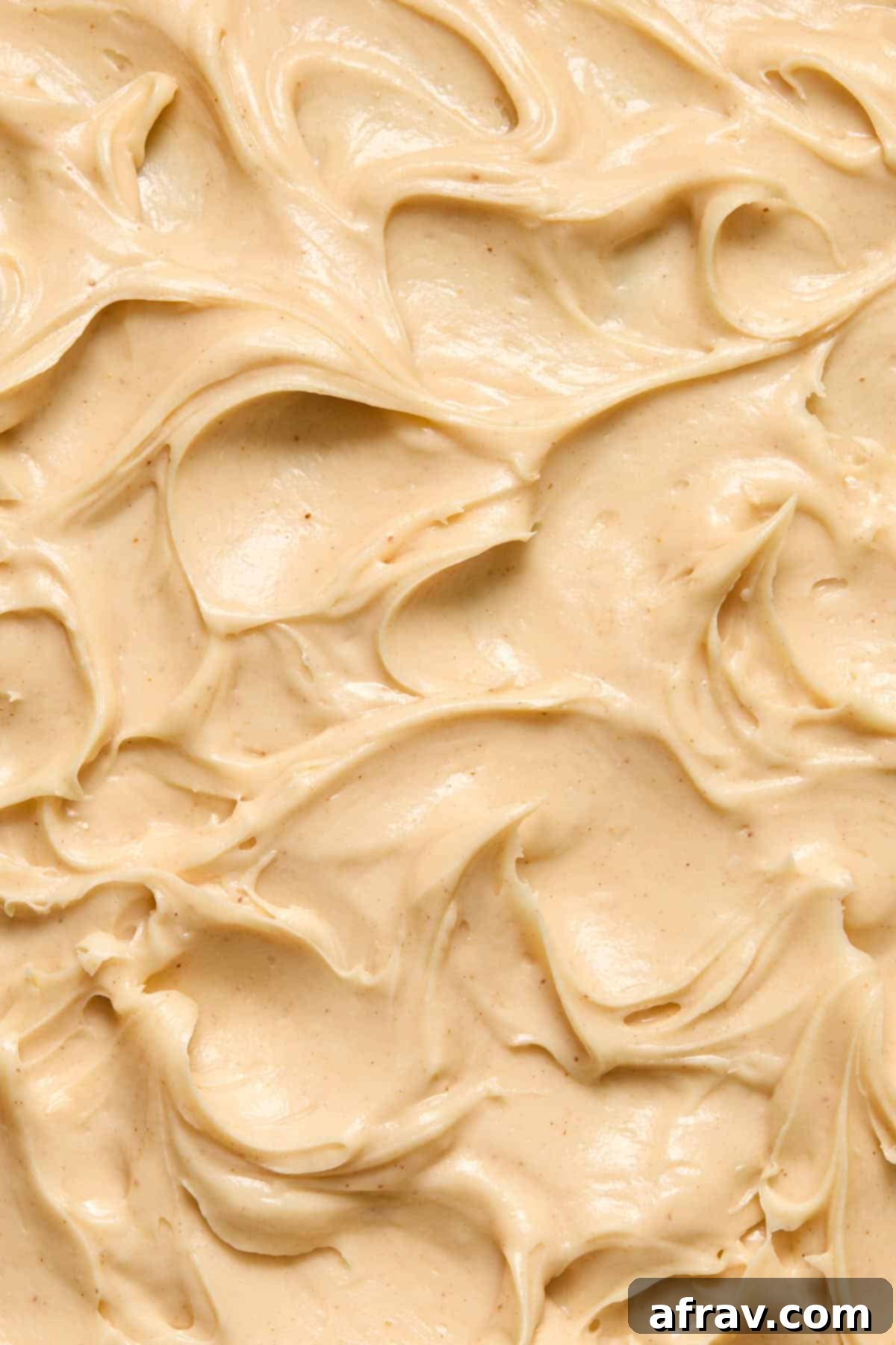 Detailed close-up of beautifully swirled peanut butter cream cheese frosting, showing its creamy and smooth texture.