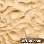 Close up view of peanut butter cream cheese frosting swirled on a cake.