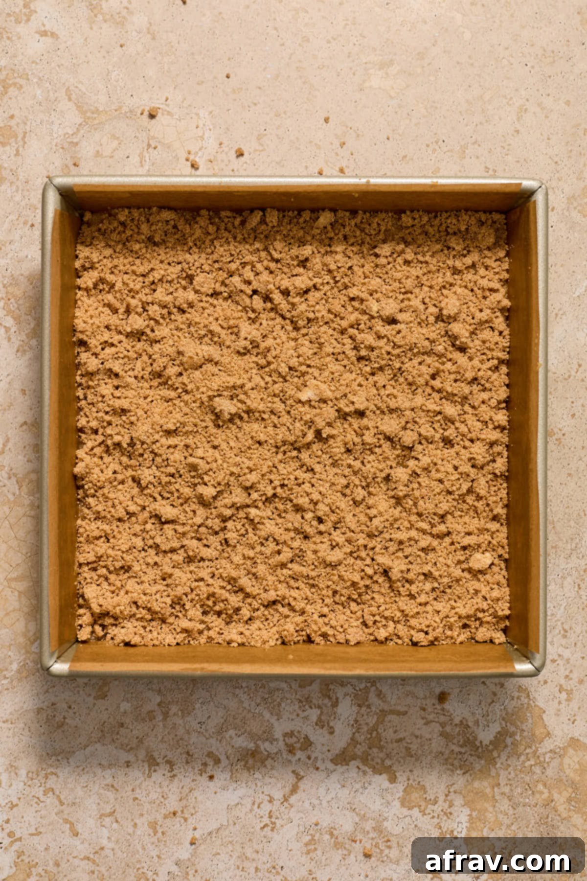 Streusel topping generously scattered over the second layer of coffee cake batter in a square pan.