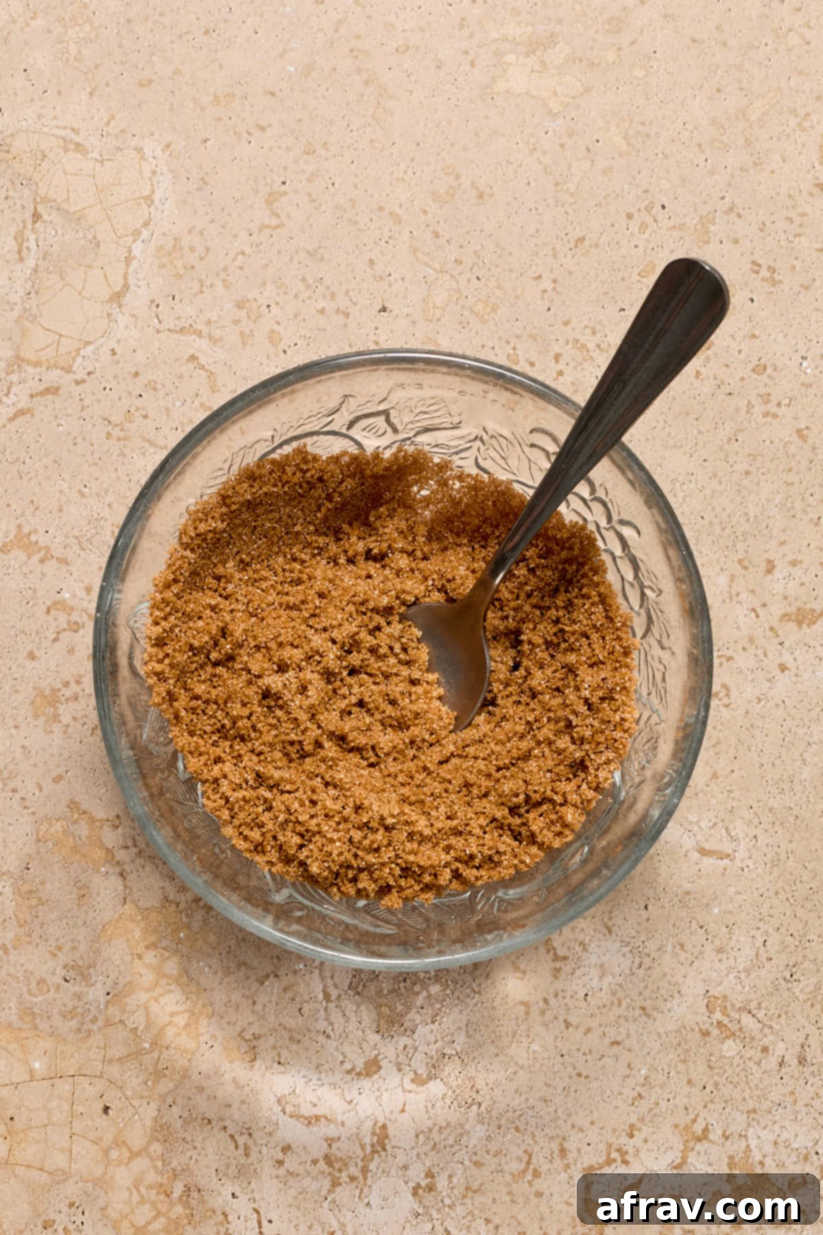 Cinnamon sugar mixture, a blend of granulated and brown sugar with cinnamon, stirred in a small glass bowl.