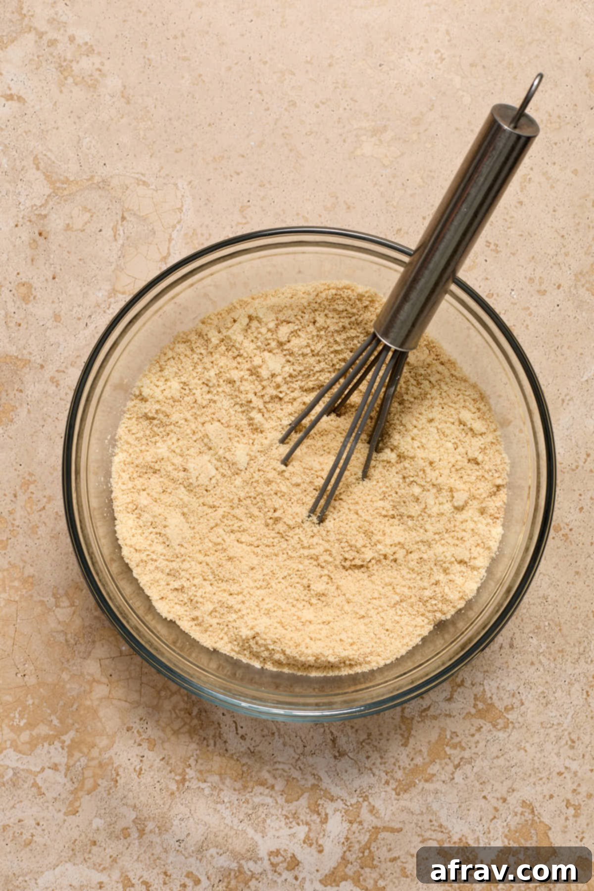 Dry ingredients for the cake, including almond flour and spices, whisked together in a bowl.