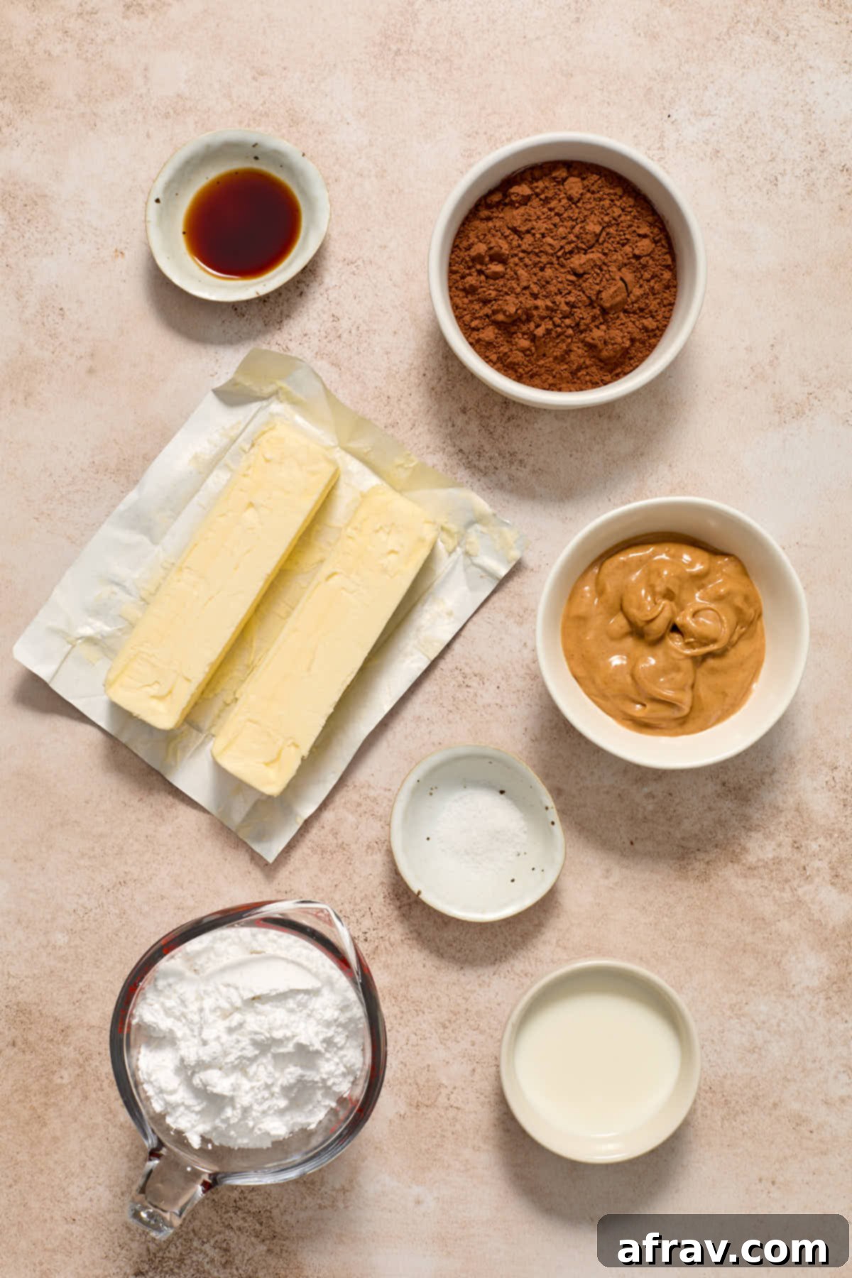Individually arranged ingredients for chocolate peanut butter frosting, including softened butter, smooth peanut butter, sifted powdered sugar, cocoa powder, milk, vanilla extract, and a pinch of salt.