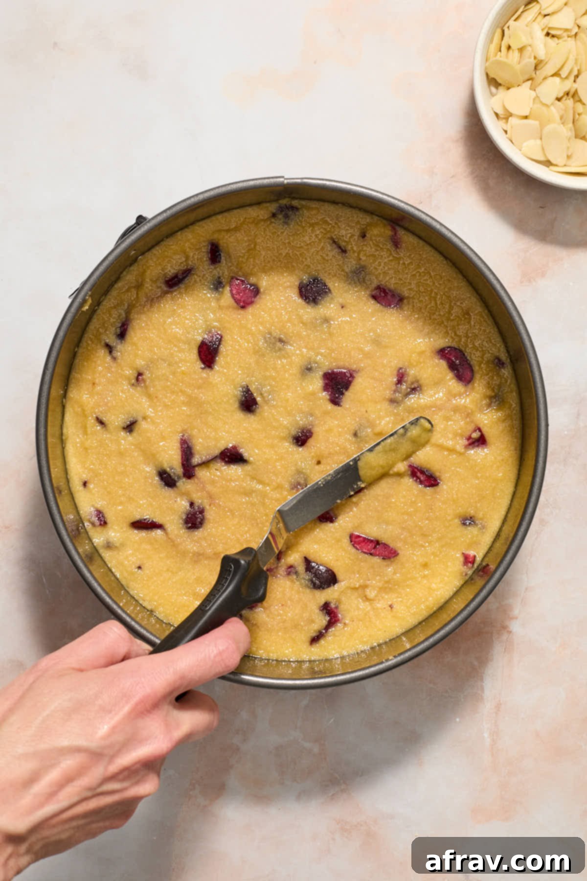 Batter being spread out in springform pan with an offset spatula.