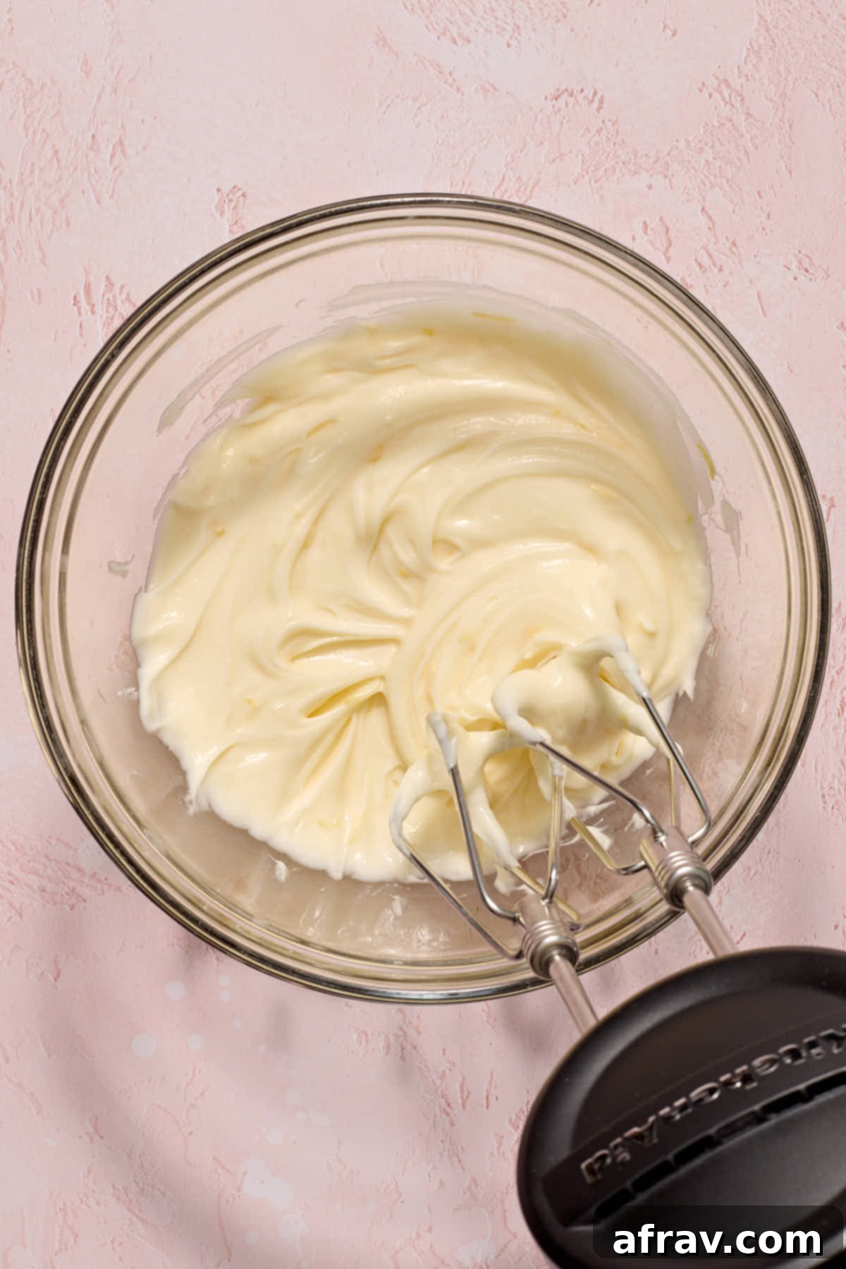 Smooth and creamy lemon cream cheese frosting mixed together in a bowl, ready to be spread.