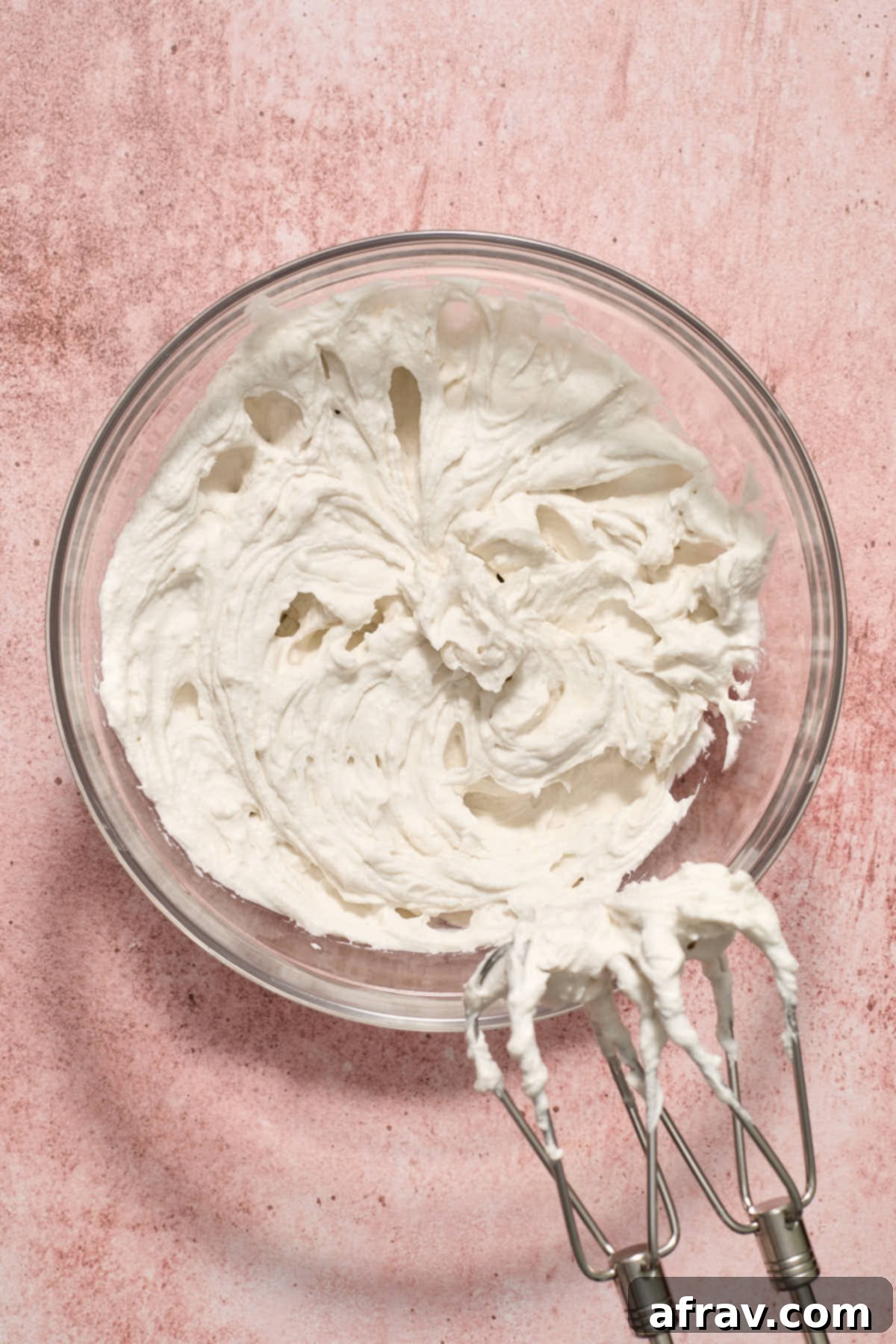Fluffy coconut whipped cream mixed together in a glass bowl, showing its light and airy texture.
