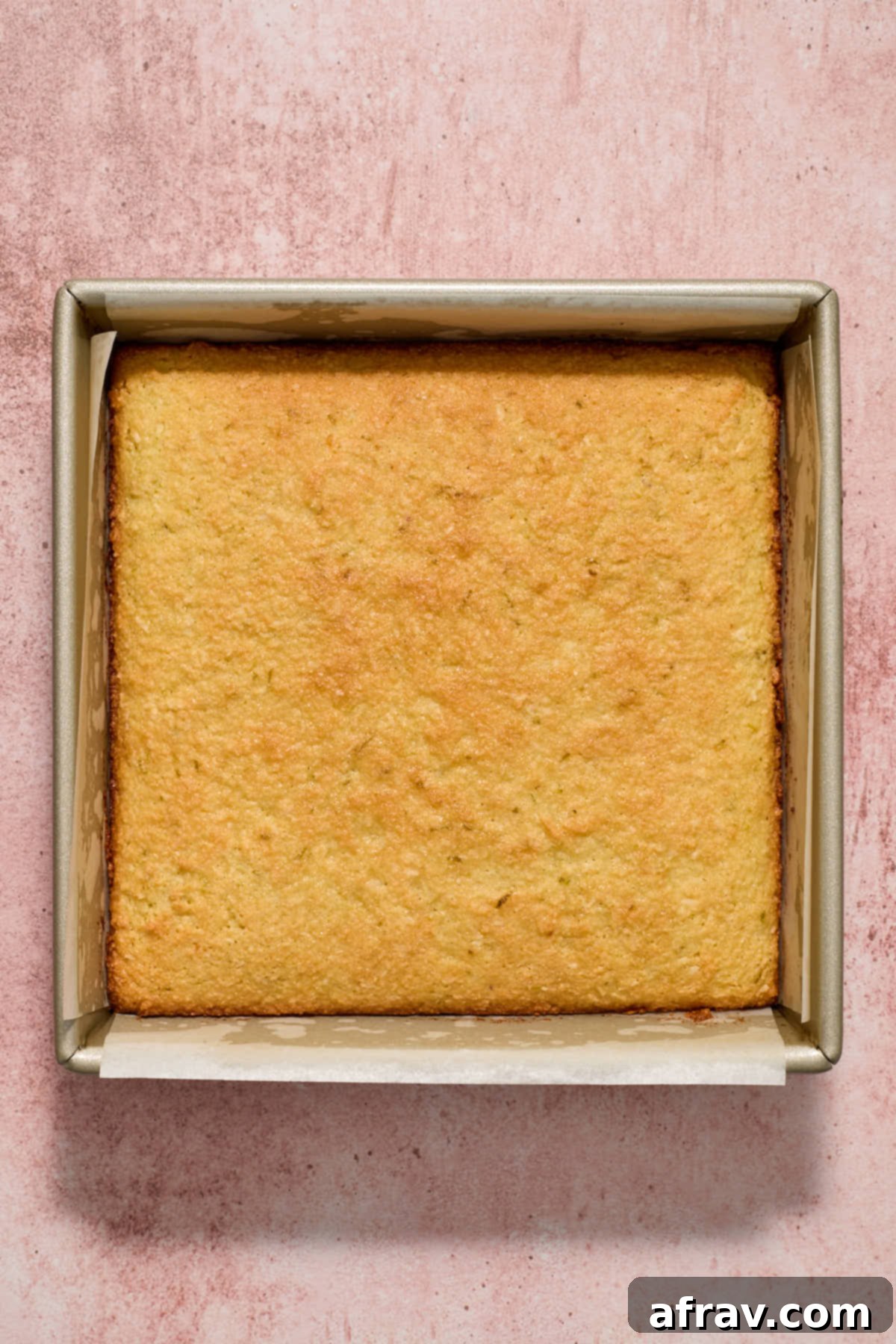 Baked almond flour coconut lime cake cooling in its square pan after being removed from the oven.