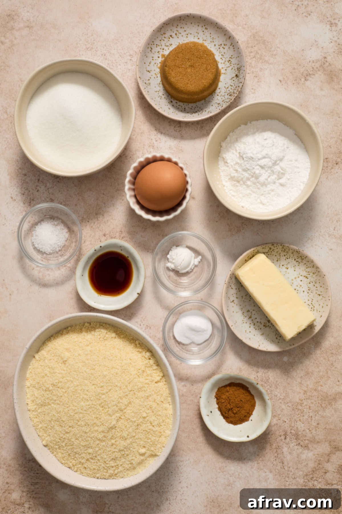Individual bowls of ingredients including almond flour, butter, sugars, cinnamon, and cream of tartar, ready to make snickerdoodles.