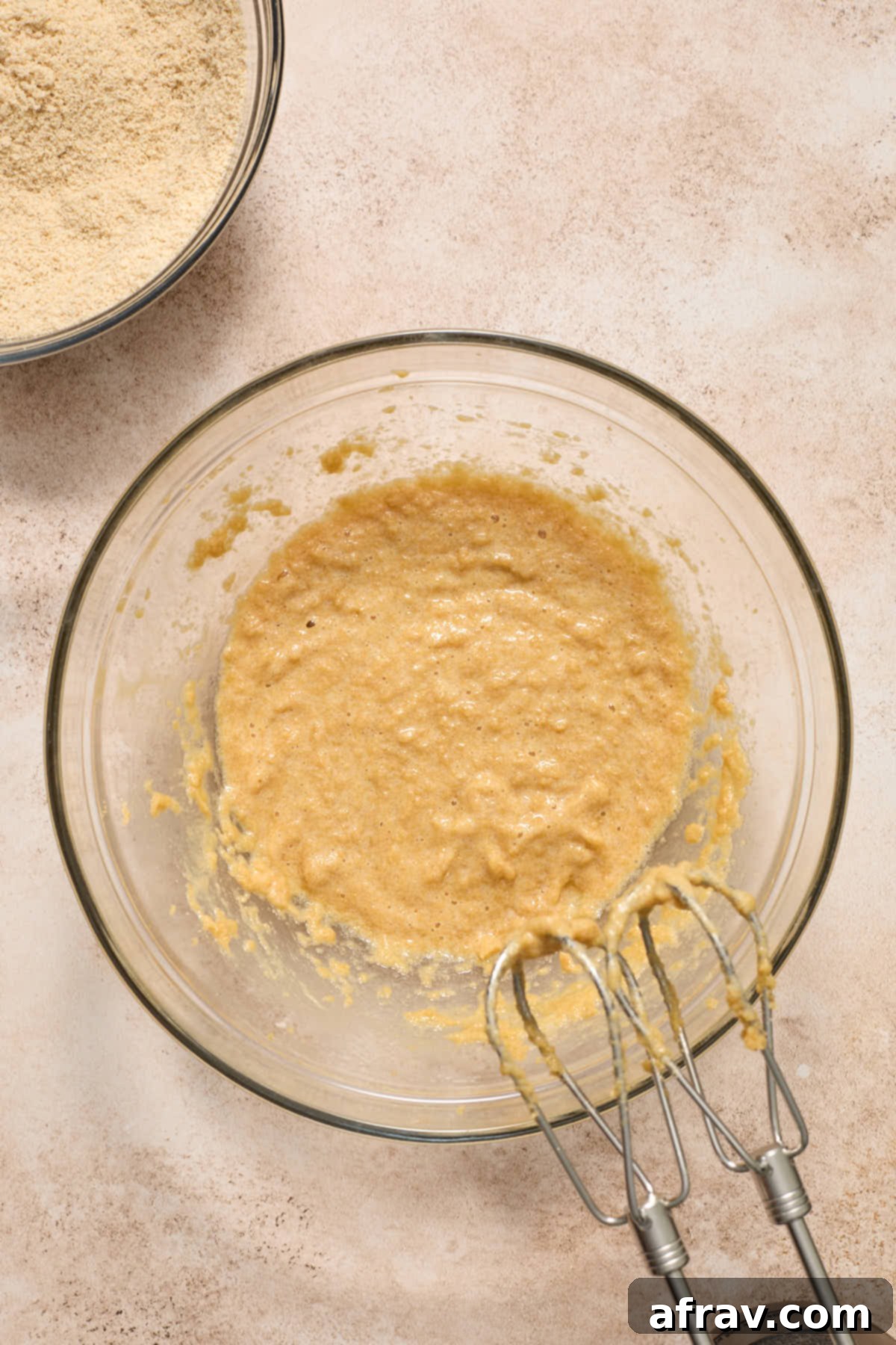Wet ingredients, including the creamed butter and sugar mixture with an egg and vanilla extract, combined in a large bowl.
