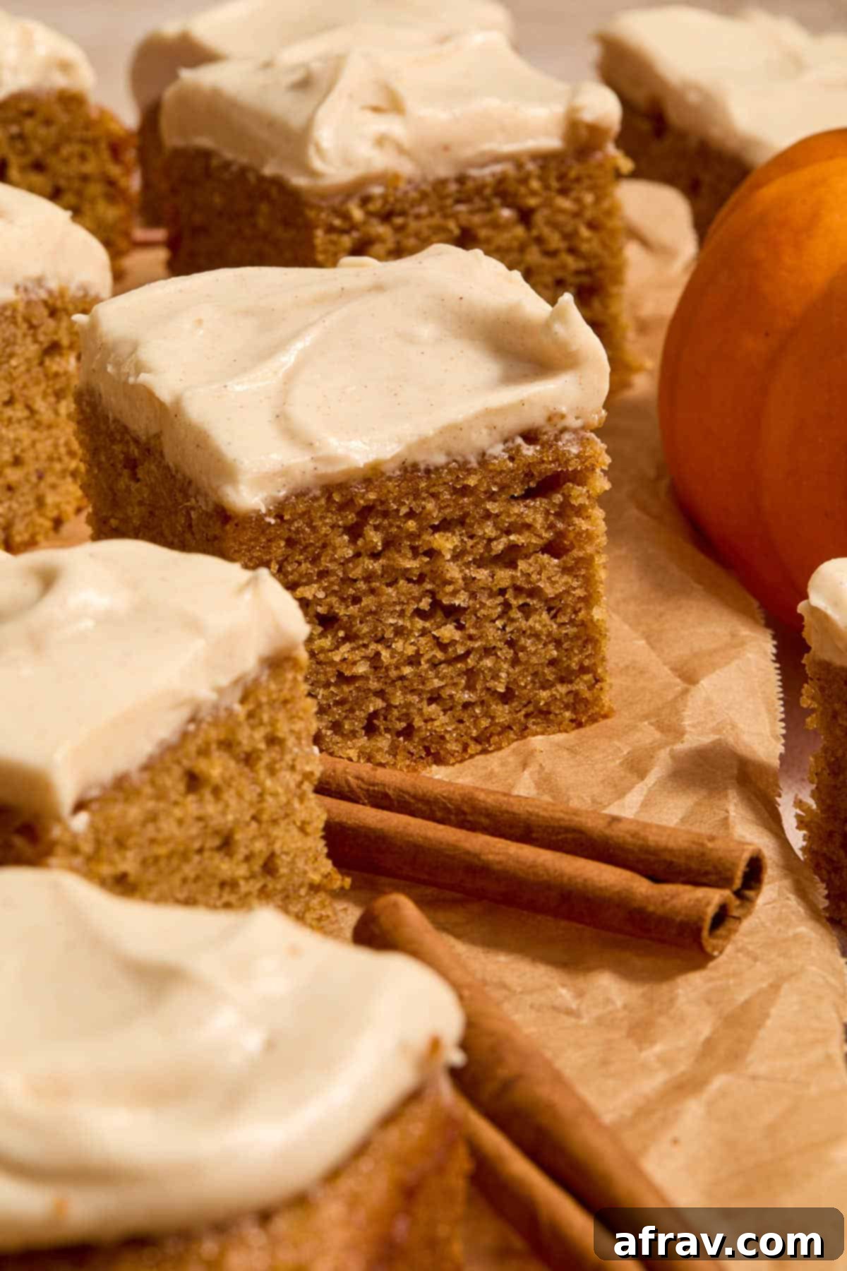 Spiced Almond Flour Pumpkin Cake 14 Side view of elegantly arranged pieces of pumpkin cake with cinnamon sticks and a small pumpkin.