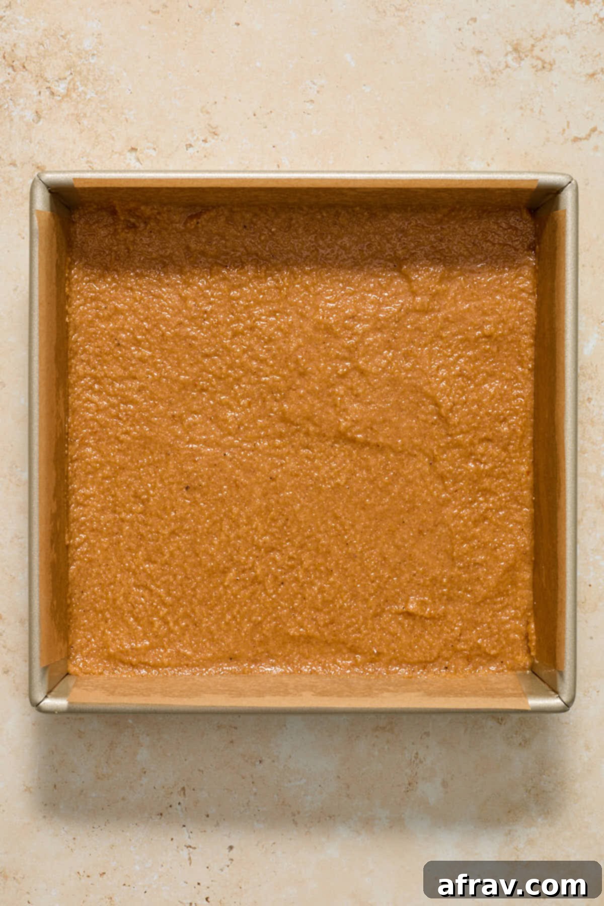 Spiced Almond Flour Pumpkin Cake 9 Cake batter evenly spread in an 8-inch square cake pan lined with parchment paper.