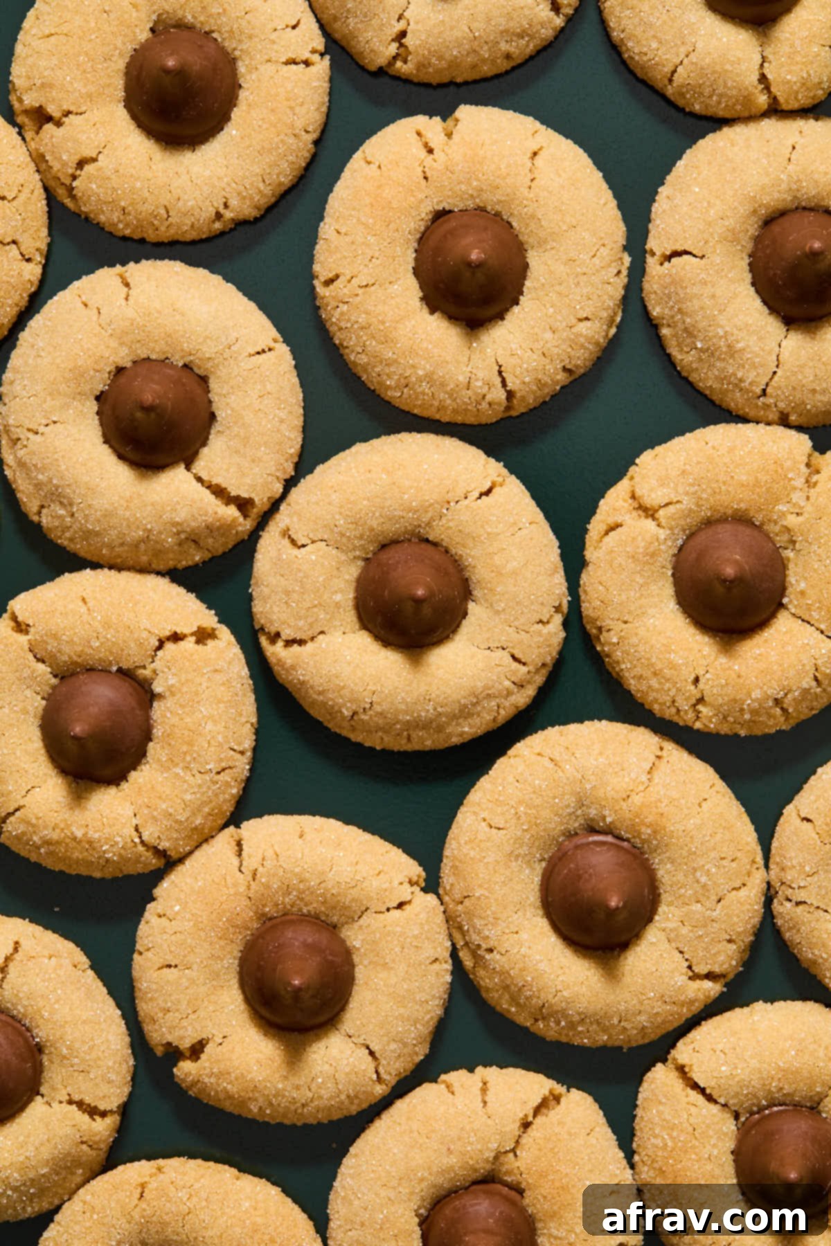 Chilled Almond Flour Peanut Butter Blossom cookies, with perfectly set chocolate kisses, arranged on a green serving tray, ready to enjoy.