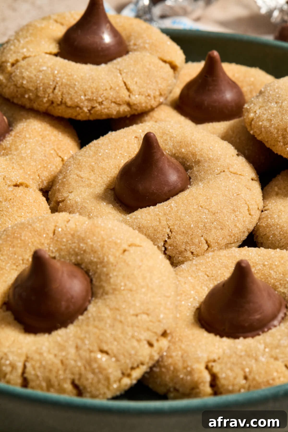 A stunning arrangement of freshly made Almond Flour Peanut Butter Blossoms on a green plate, highlighting their perfect shape and chocolate kiss toppings.