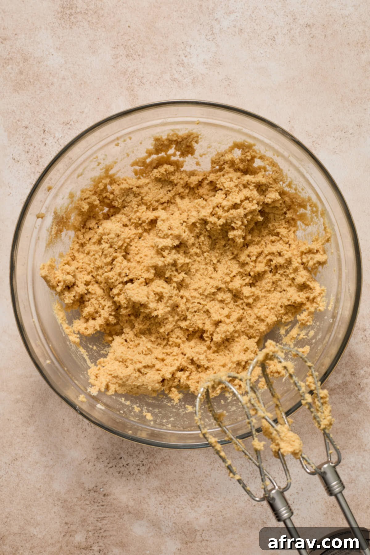 A perfectly blended cookie dough, with almond flour, peanut butter, and other ingredients, visible in a clear glass bowl, ready for chilling.
