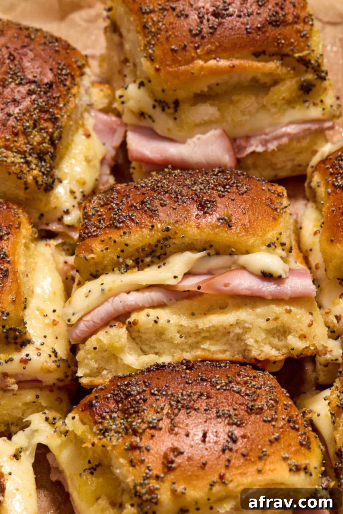 Close up view of a ham and cheese slider turned on its side.
