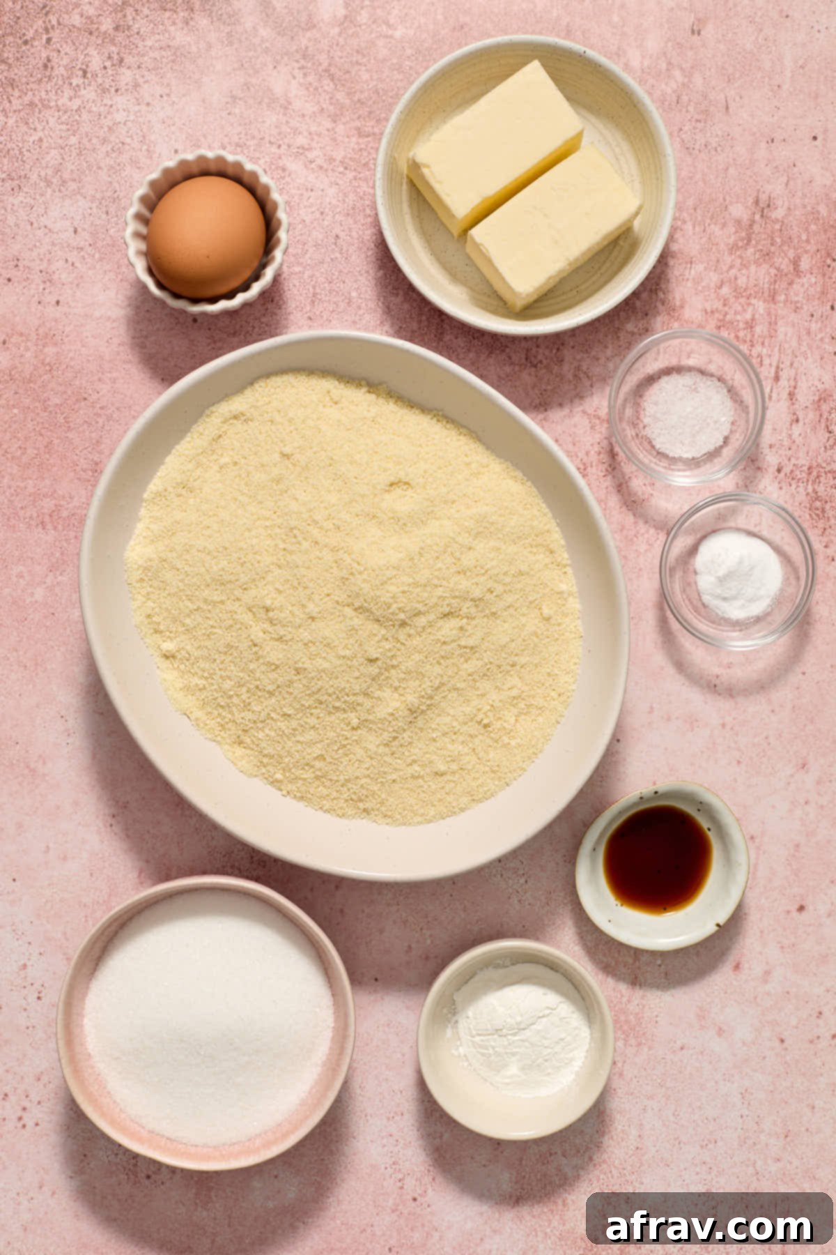 Ingredients to make almond flour sugar cookies arranged in individual bowls, including almond flour, sugar, butter, and cornstarch.