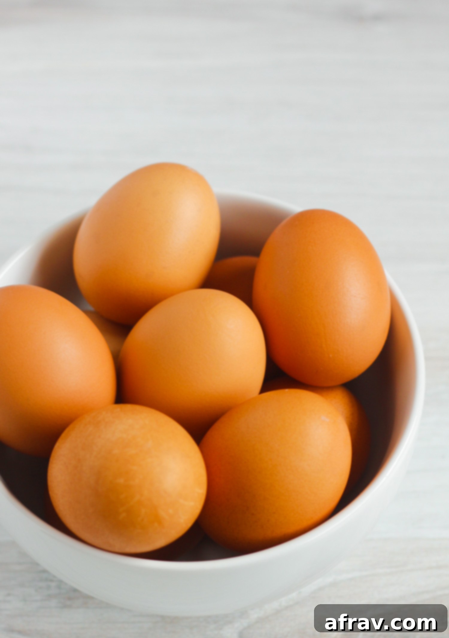 side view of brown eggs in white bowl