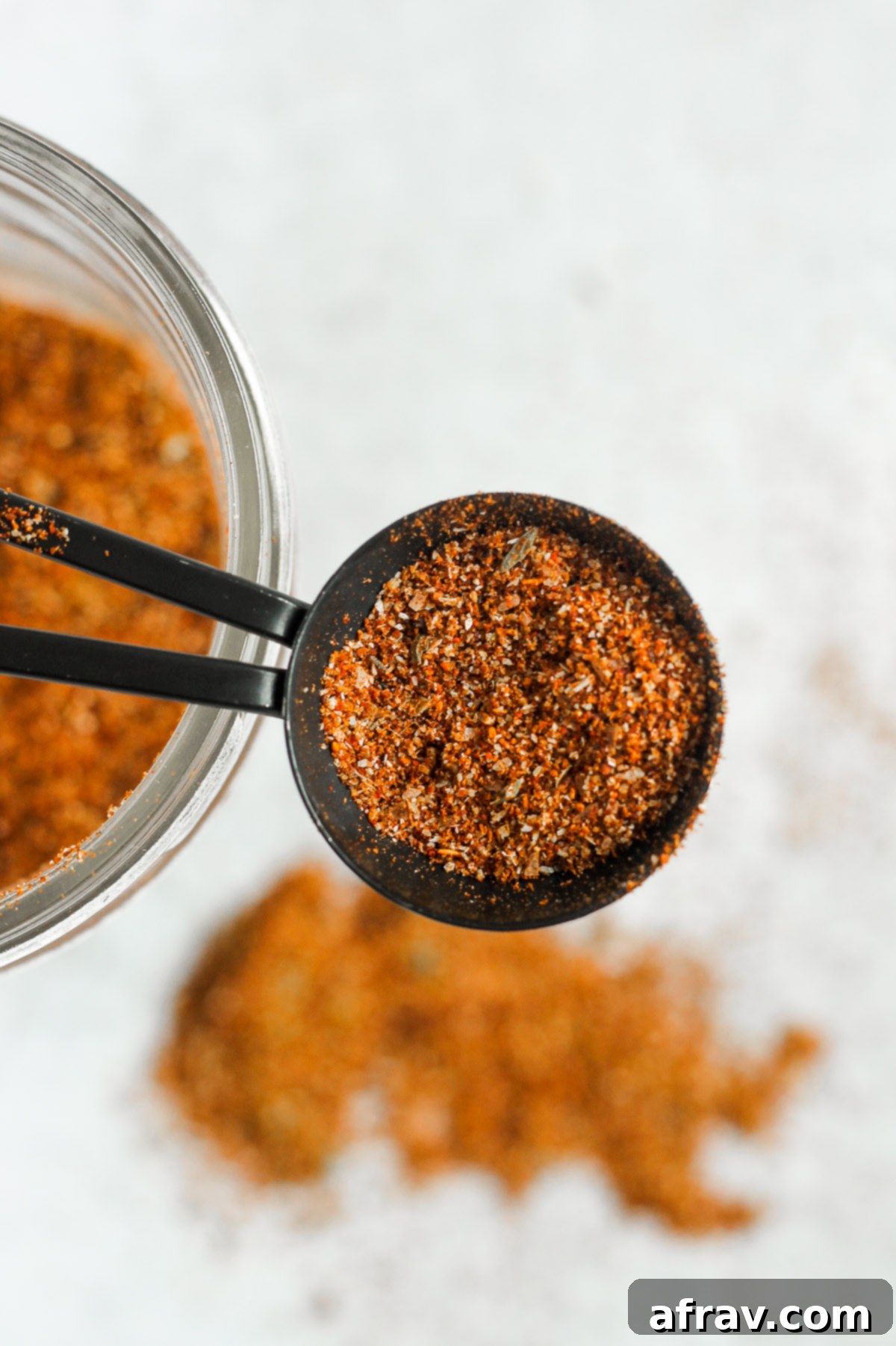overhead view of homemade taco seasoning recipe in black teaspoon