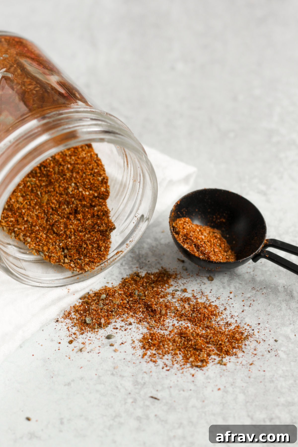 taco seasoning being poured from a mason jar