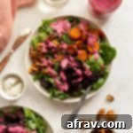 Roasted Beet and Carrot Salad arranged on plates and topped with cranberry salad dressing, a truly festive dish.