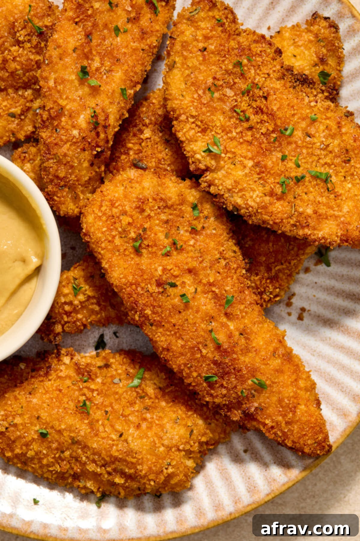Close up view of crispy chicken strips on a plate.