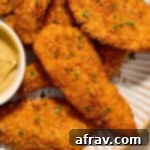Close up view of air fryer cornflake chicken strips on a plate.