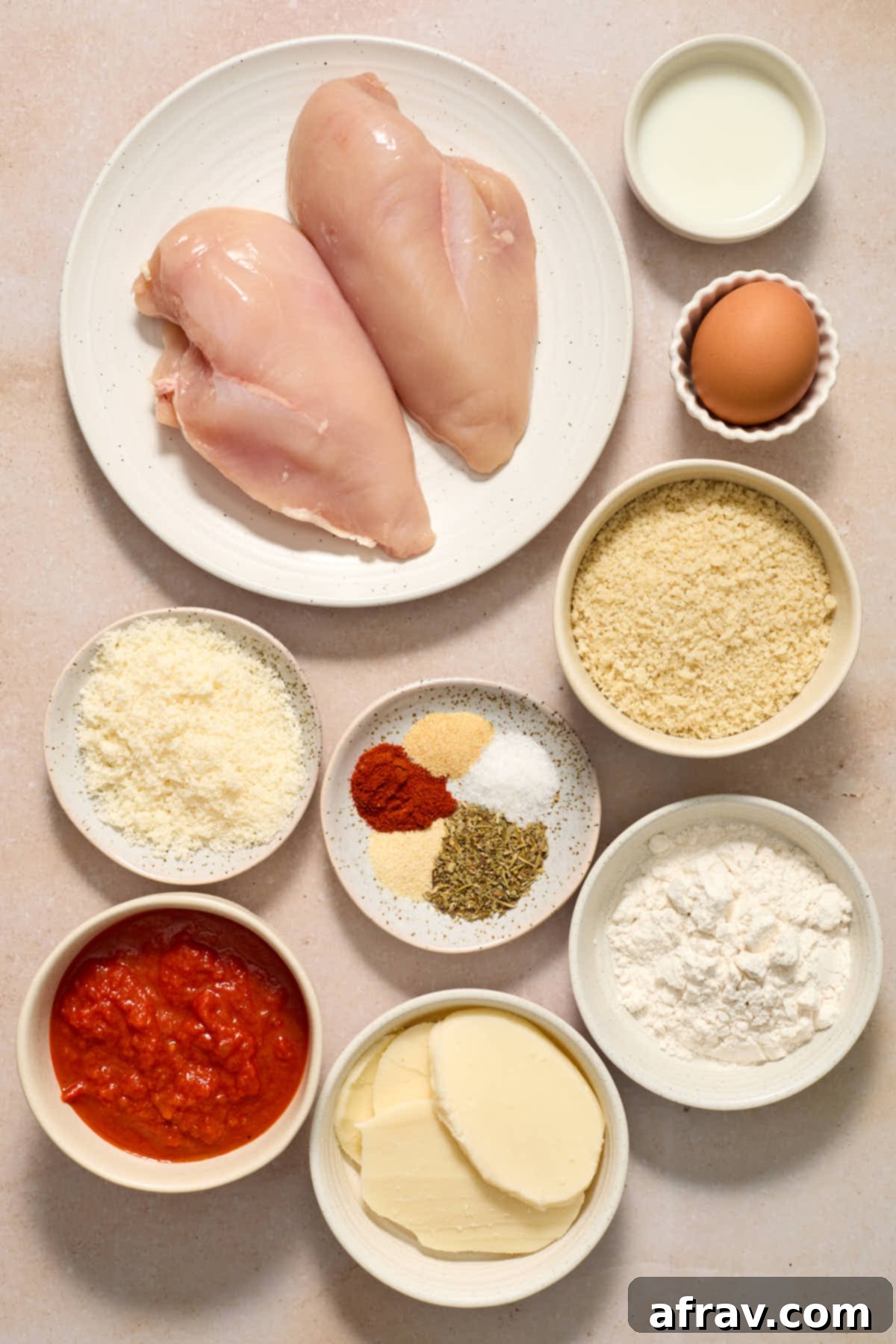 Ingredients to make air fryer chicken parmesan arranged in individual bowls.