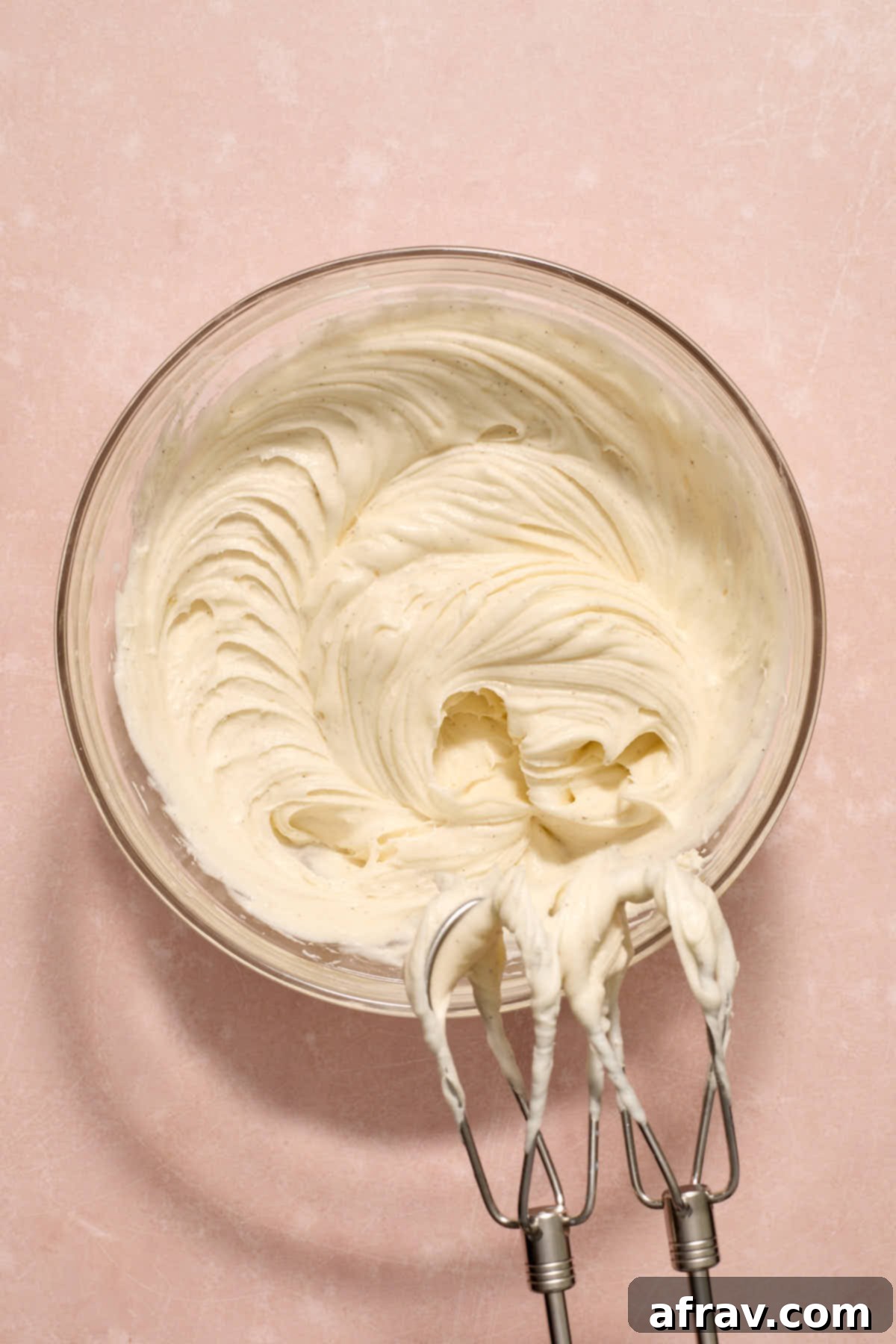 Double Sour Cream Banana Cake 11 Smooth and creamy sour cream frosting, whipped to perfection in a glass mixing bowl, ready to be spread.