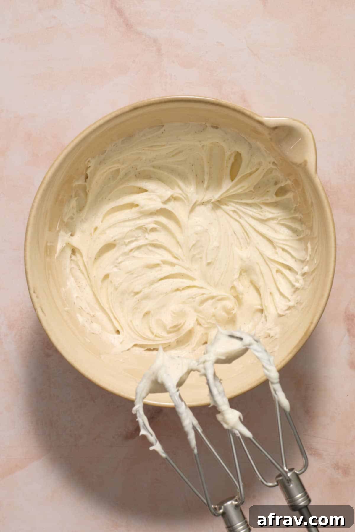 Frosting mixed together in a beige bowl.