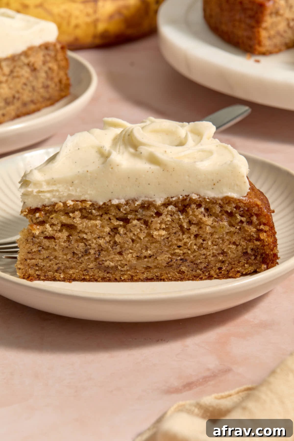 Front facing view of a slice of cake served on a plate with a fork.
