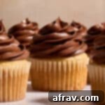 Side view of chocolate sour cream frosting piped on top of cupcakes.