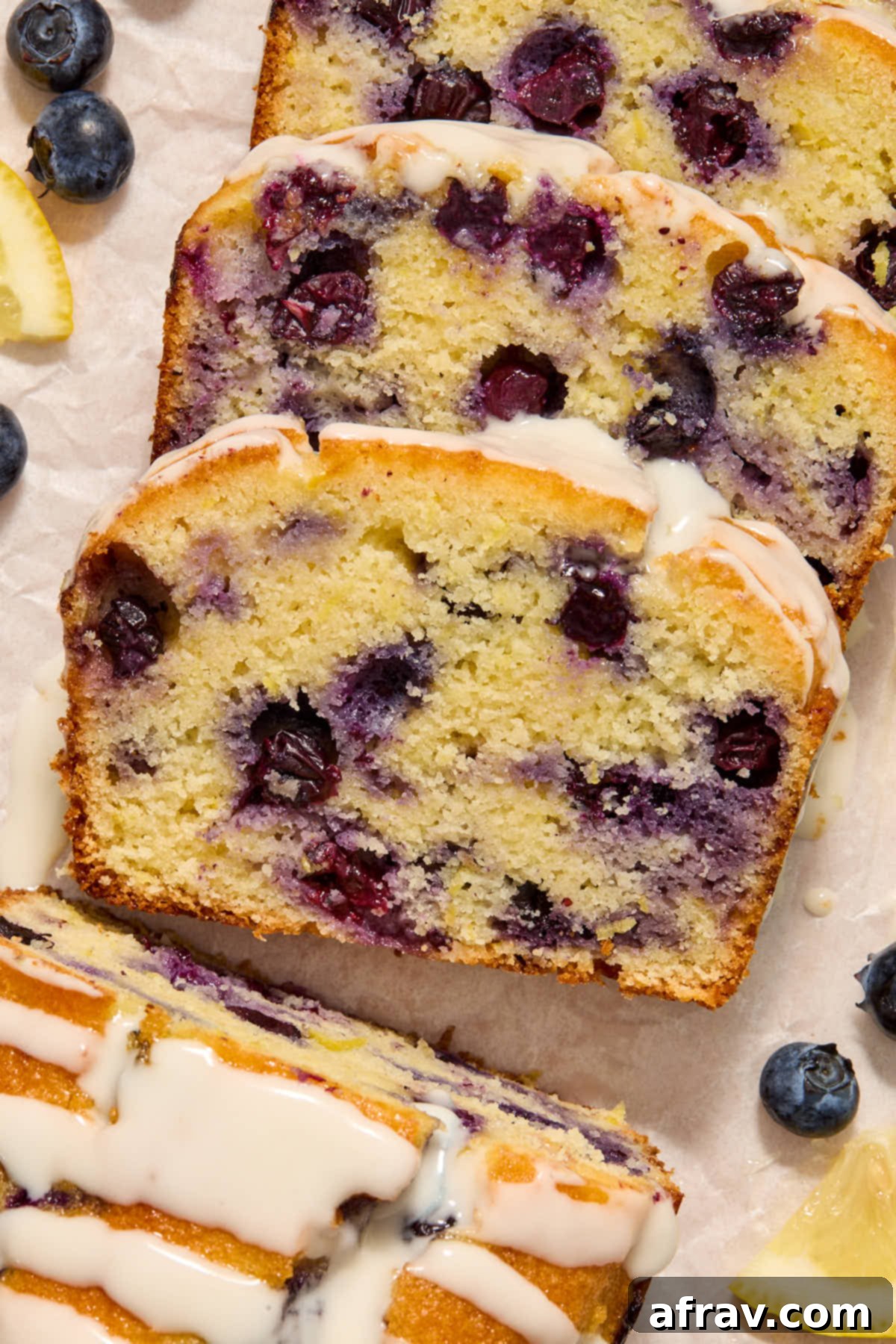 Slices of bread arranged on white parchment paper with blueberries and lemon slices in the frame.
