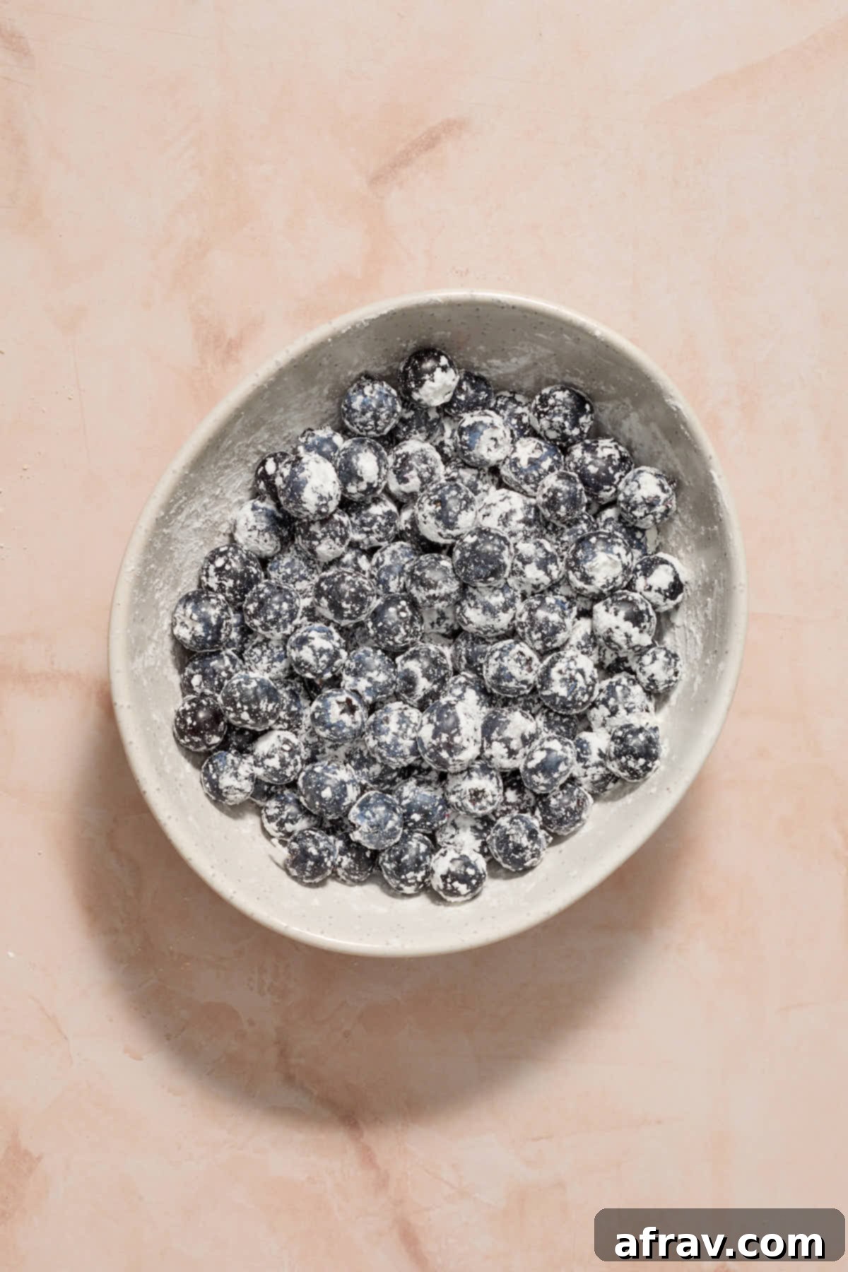Blueberries in a white bowl and tossed with cornstarch.