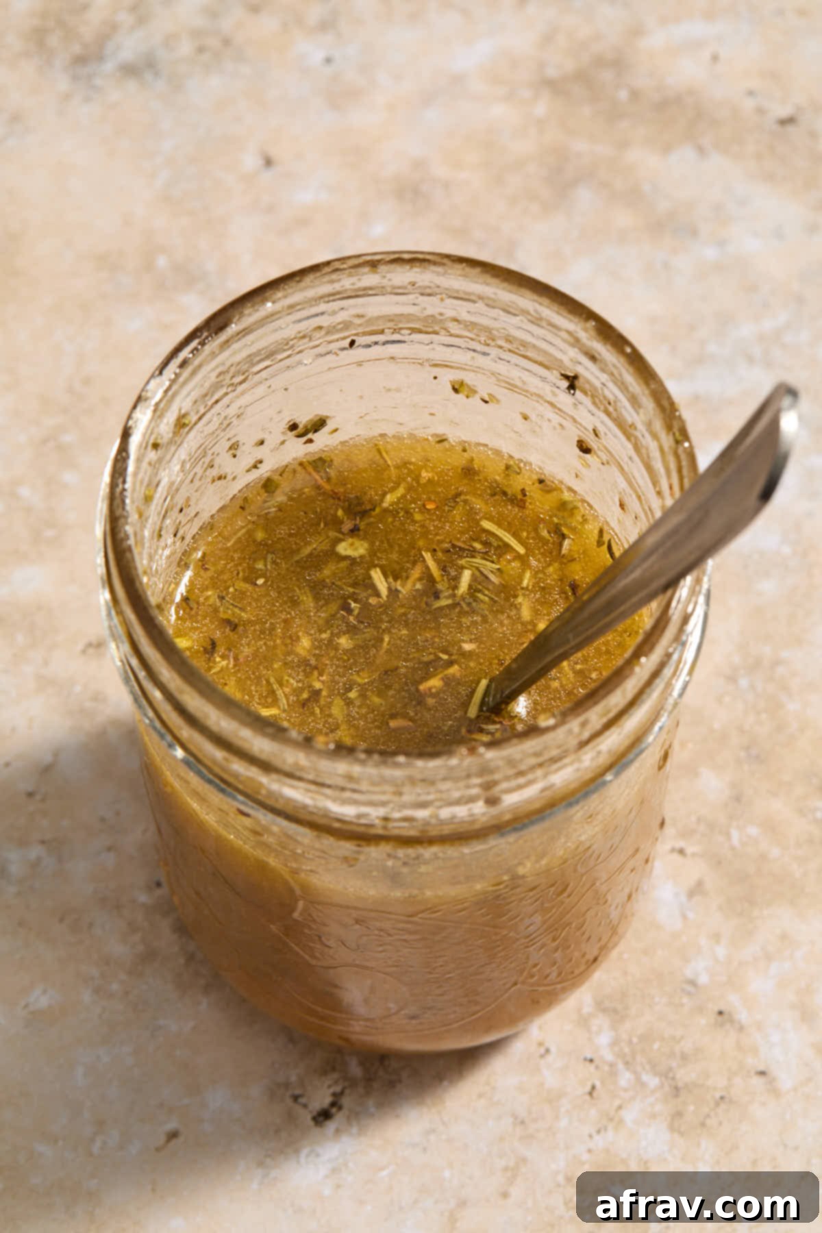 Homemade Italian vinaigrette in a glass jar, ready to be shaken.
