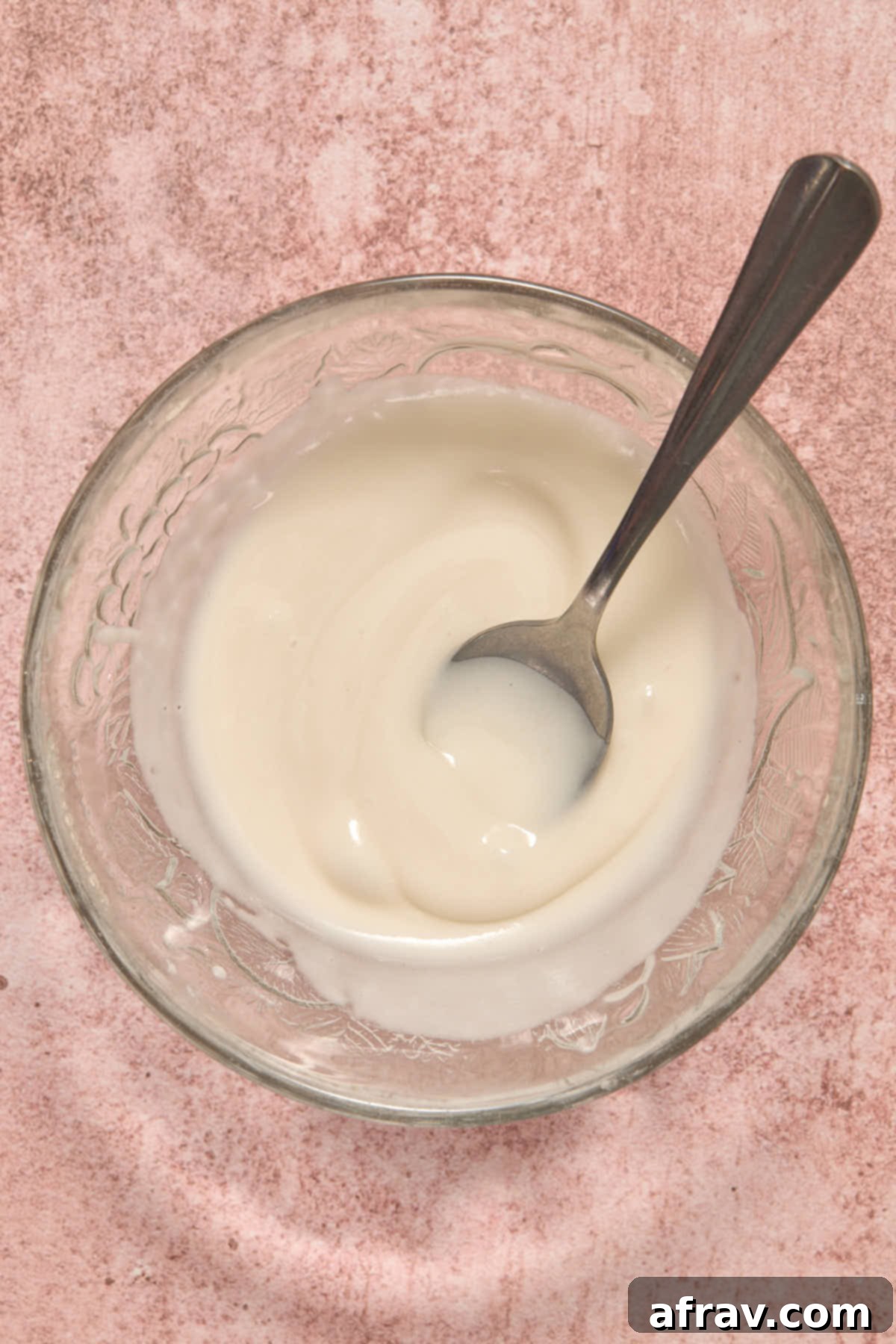 Powdered sugar glaze mixed together in a small glass bowl, smooth and ready to use.