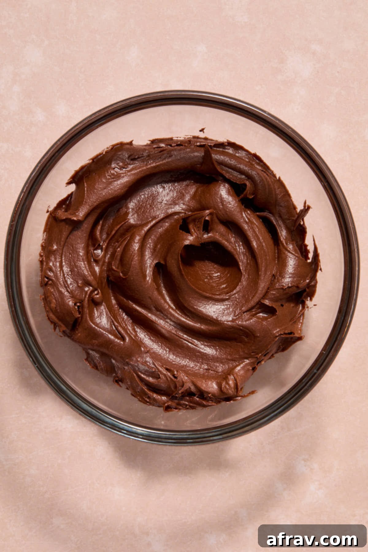 Chocolate frosting in a glass bowl.